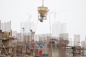 Construction workers prepare to pour concrete as high-rise apartment buildings behind them are shrouded by haze in Singapore September 30, 2015. Slash-and-burn agriculture in neighbouring Indonesia has blanketed Singapore in a choking haze for weeks. REUTERS/Tim Wimborne